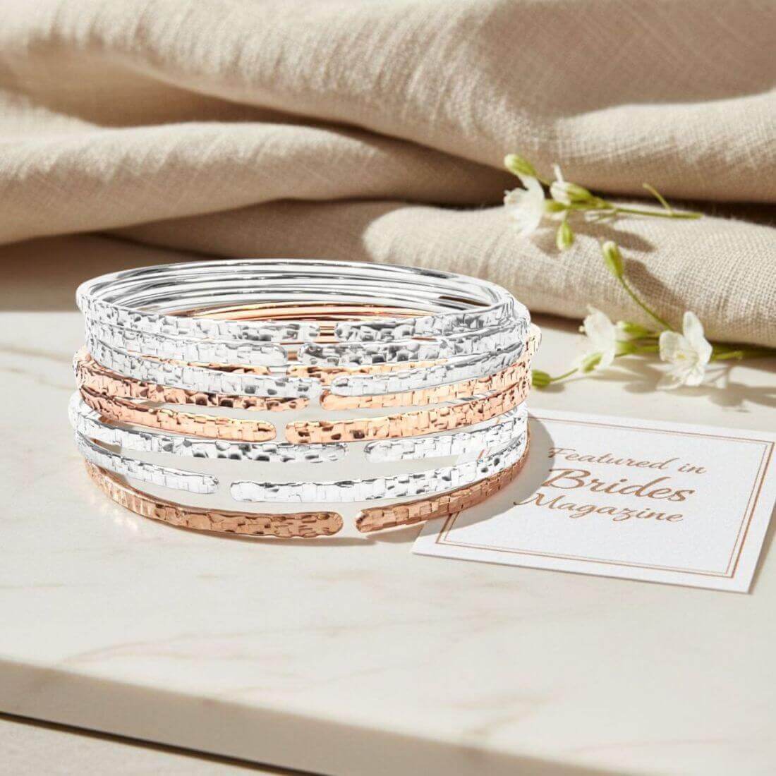 10 Gauge 925 Silver Hammer Textured Bangle stacked with rose gold bangles on a marble surface.