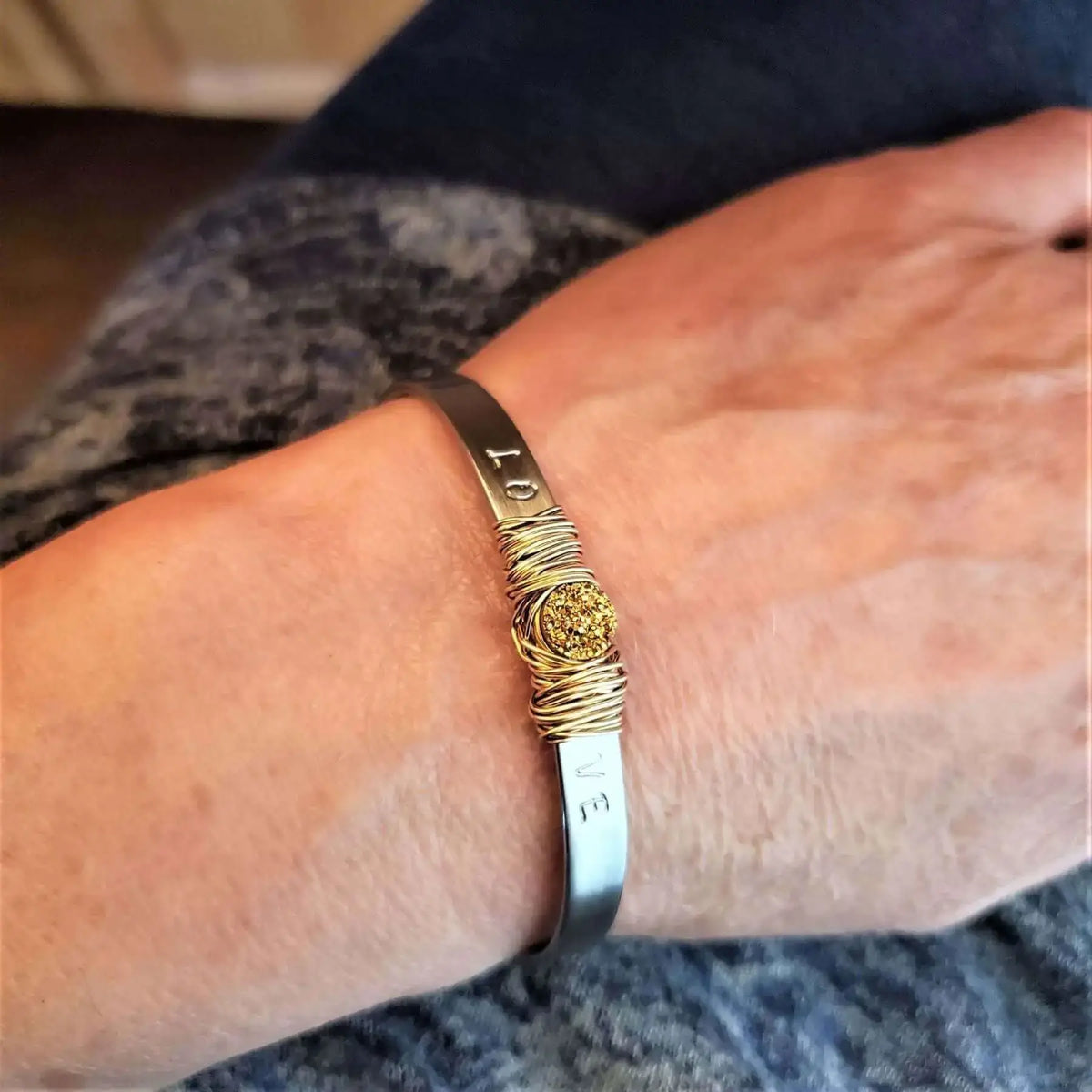 A handmade bracelet showcasing The Benefits of Stainless Steel Versus Aluminum Jewelry on a wrist.