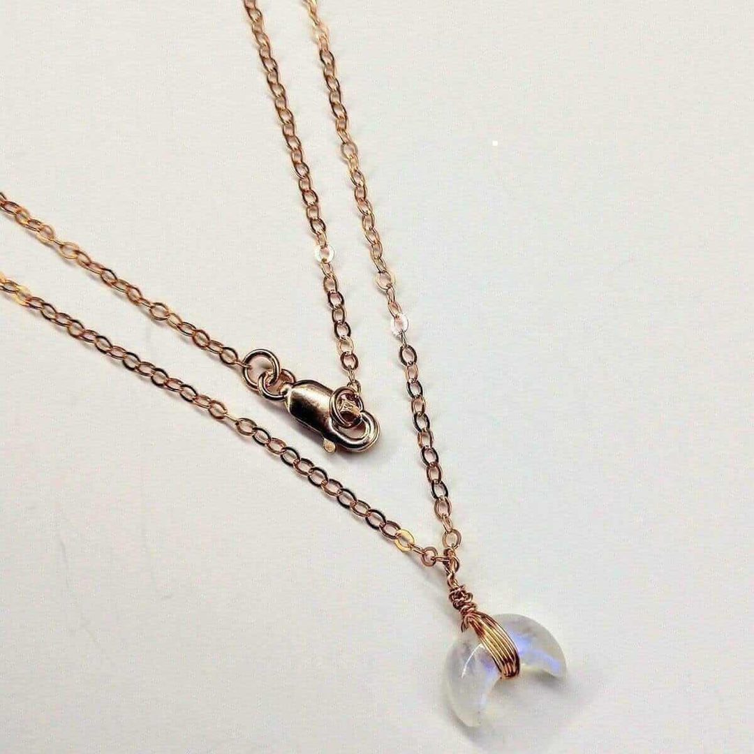 Enchanting World of Moonstone pendant necklace featuring a delicate moonstone charm on a layered chain.