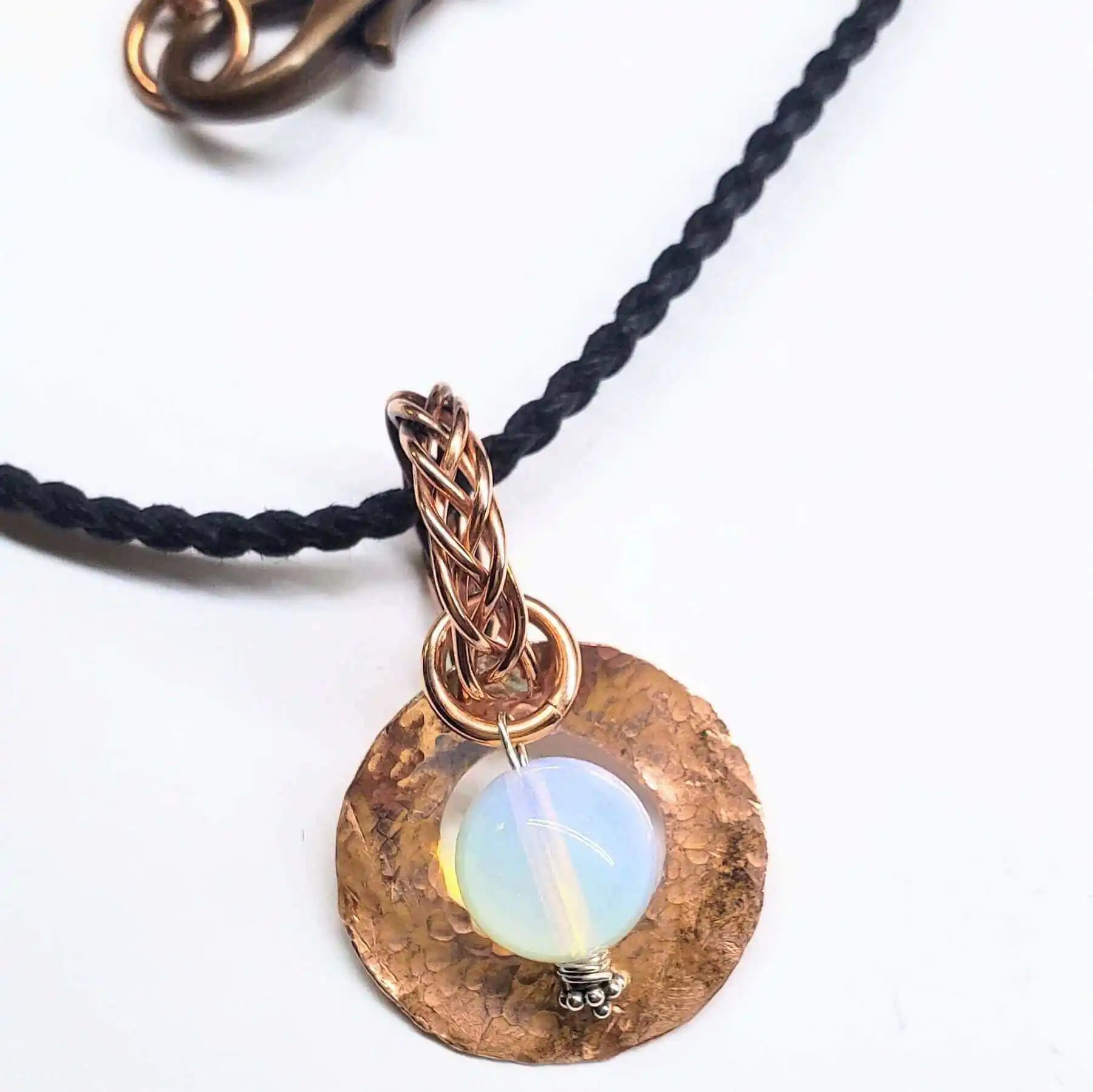 Handmade copper jewelry pendant with an opalescent bead, demonstrating techniques on how to solder handmade copper jewelry.