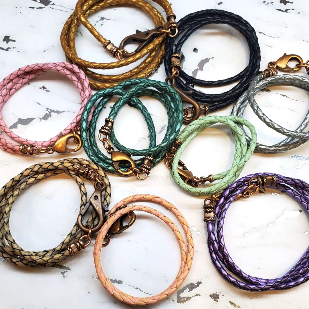 Handmade single leather necklaces in various colors and styles, showcasing intricate braided designs and unique clasps.