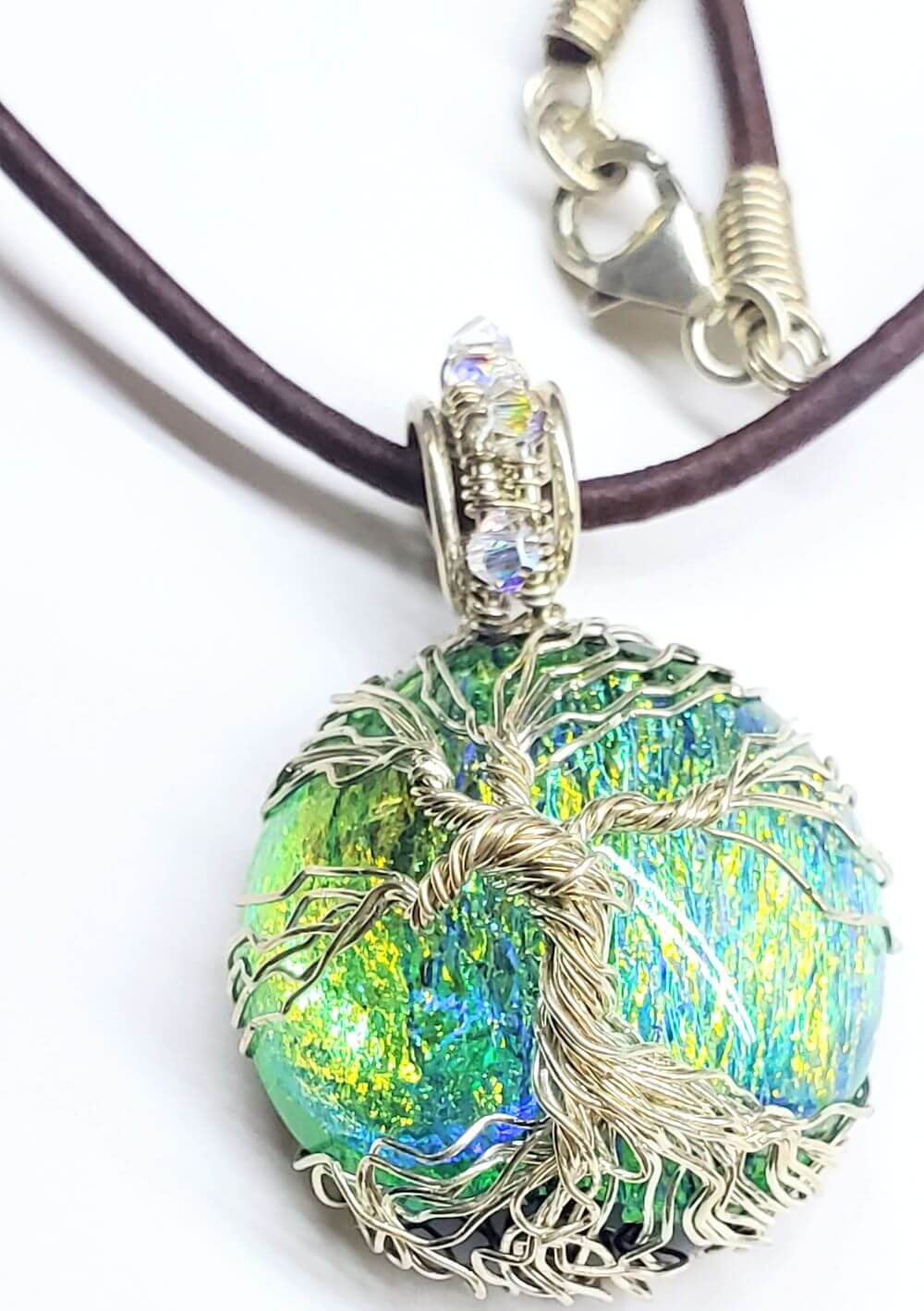 Unique handmade Tree of Life jewelry featuring a colorful pendant on a leather necklace.