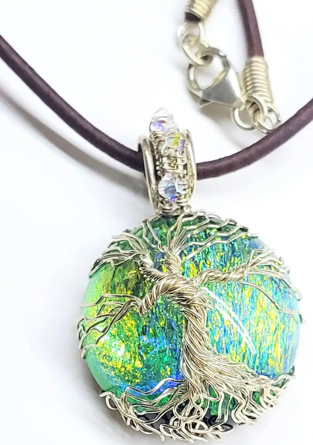Unique handmade Tree of Life jewelry featuring a colorful pendant on a leather necklace.