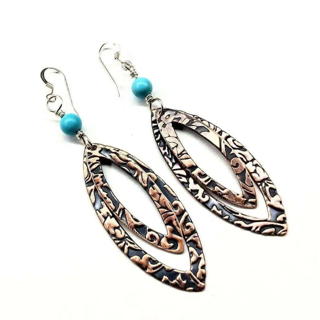Handmade boho style jewelry featuring intricate copper earrings with turquoise accents and a free-spirited design.