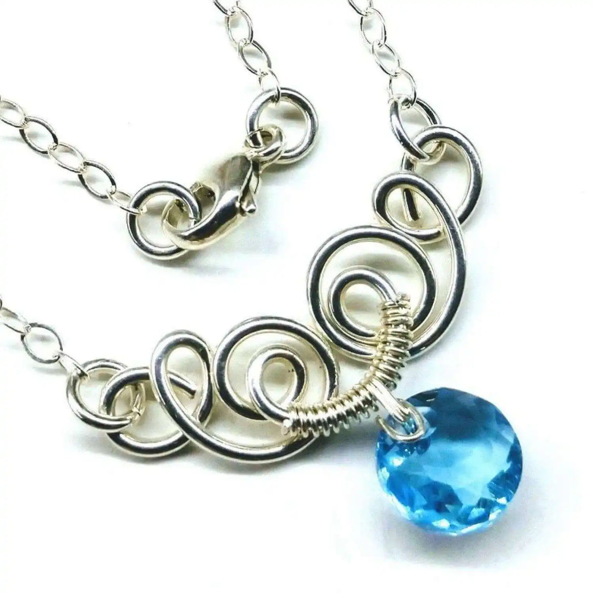 Handmade Jewelry Wire Sculpted Jewelry featuring a silver necklace with blue gemstone and intricate wire design.