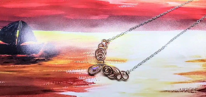 Handmade Sculpted Copper Silver Angel in Flight Necklace showcasing intricate design against a vibrant background.