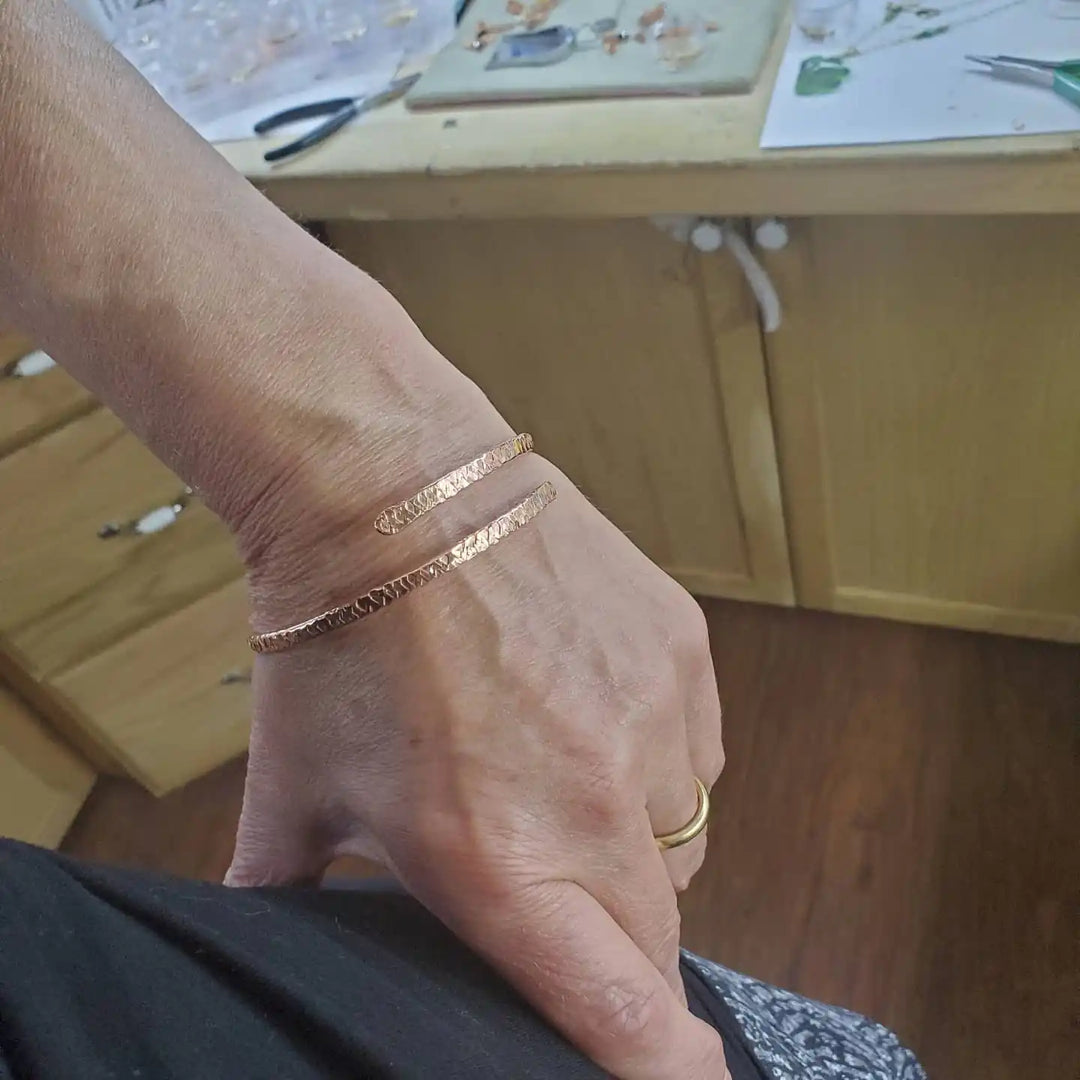 Unisex 8 Gauge Adjustable Hammered Copper Overlap Bangle worn on hand showcasing its design and craftsmanship