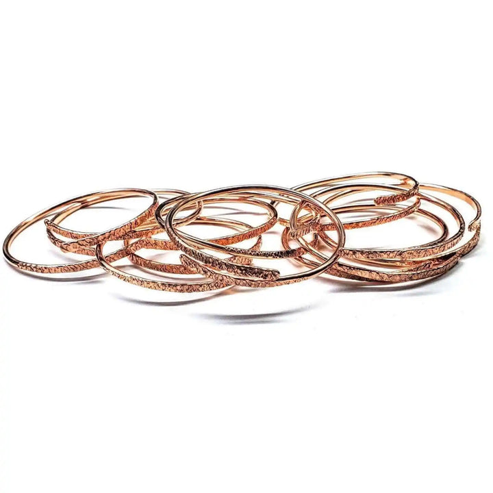 Unisex 8 Gauge Adjustable Hammered Copper Overlap Bangle displayed among other stylish bangles.