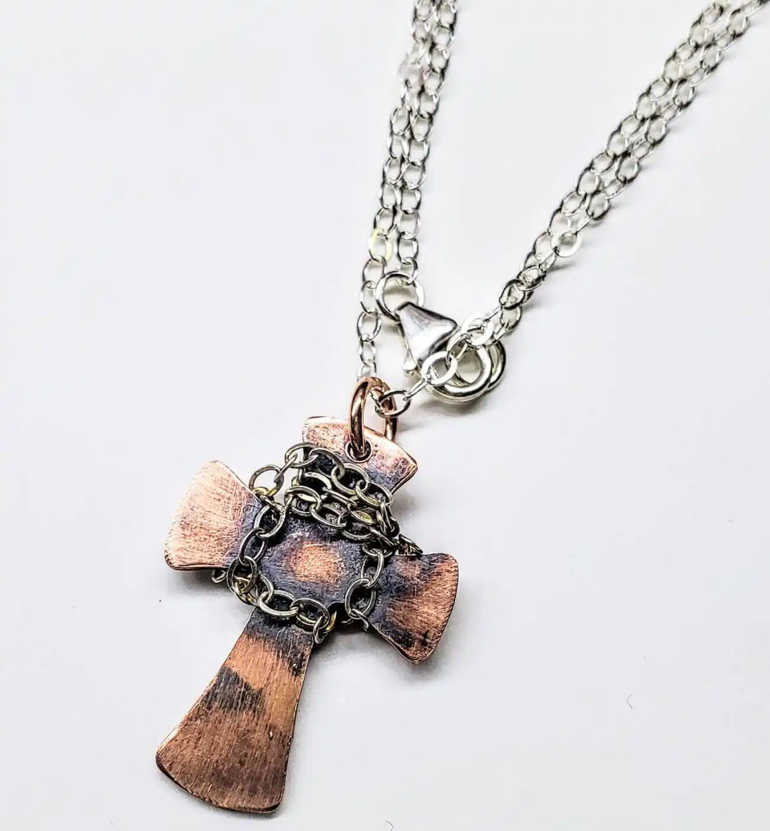 Chained Hammered Copper Cross Necklace For Him Or Her displayed on a silver chain, showcasing its unique craftsmanship.