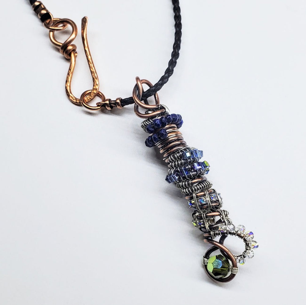 Necklace with blue beads and a green pendant on a white background