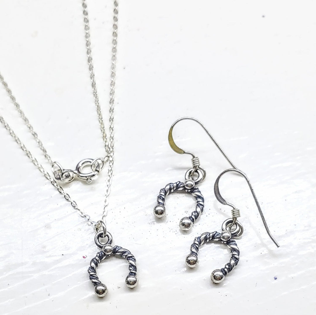 Handmade sterling silver horseshoe jewelry set featuring necklace and earrings in a stylish design.