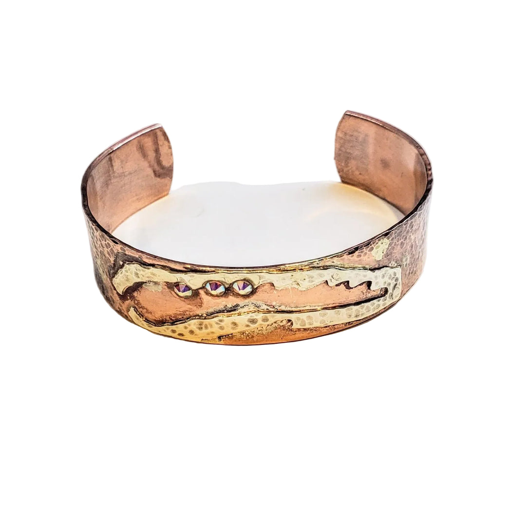 Copper bracelet with embedded stones on a light background