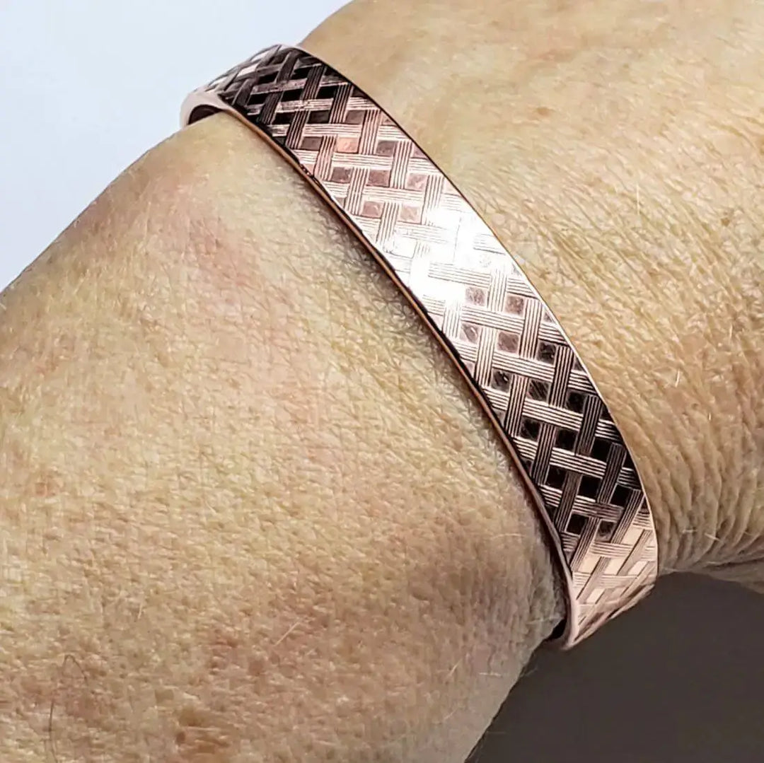 His and Her Copper Embossed Weave Cuffs 16 Gauge displayed on a wrist, showcasing a stylish artisan design.
