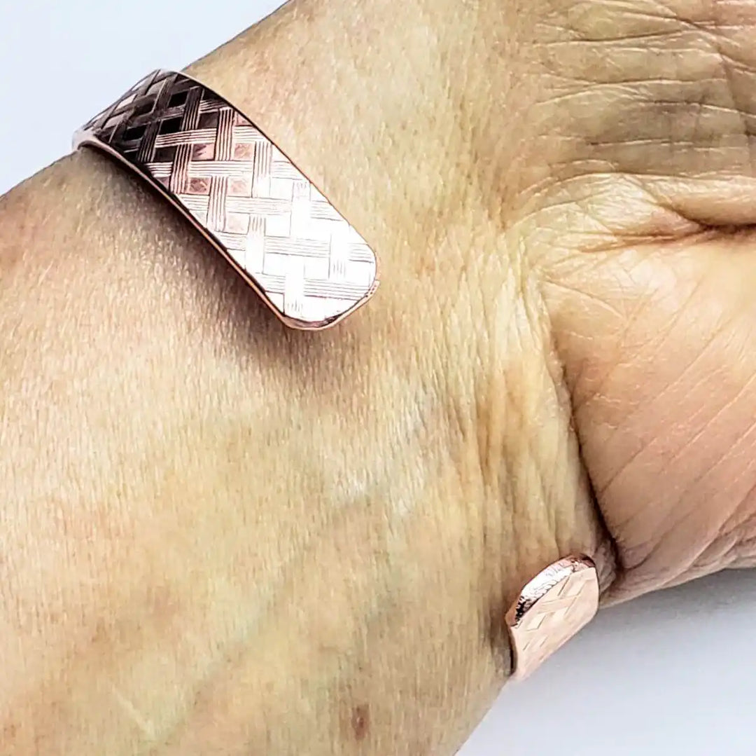 His and Her Copper Embossed Weave Cuffs 16 Gauge worn on a wrist showcasing the artisan-crafted design.