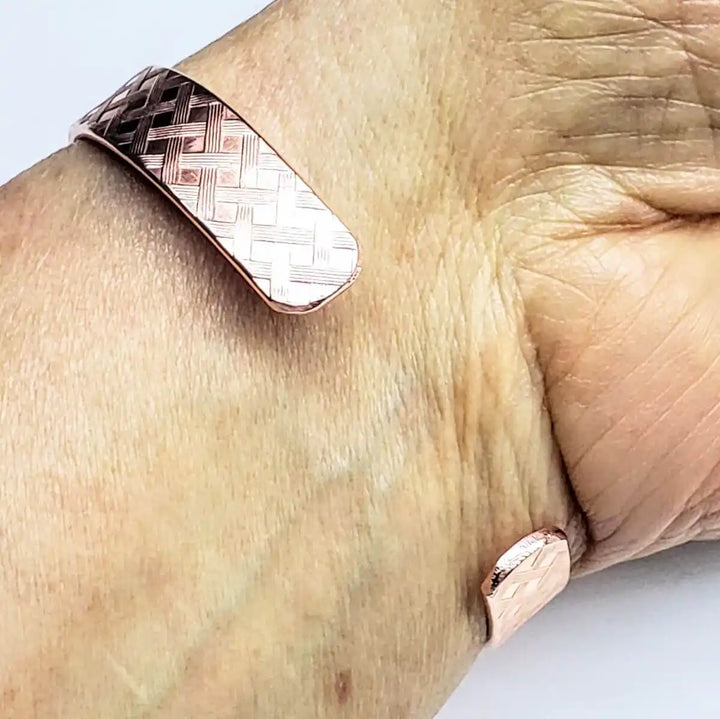 His and Her Copper Embossed Weave Cuffs 16 Gauge worn on a wrist showcasing the artisan-crafted design.