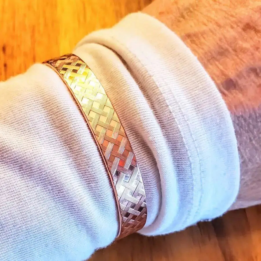 His and Her Copper Embossed Weave Cuffs 16 Gauge – Close-up of a copper bracelet on wrist.