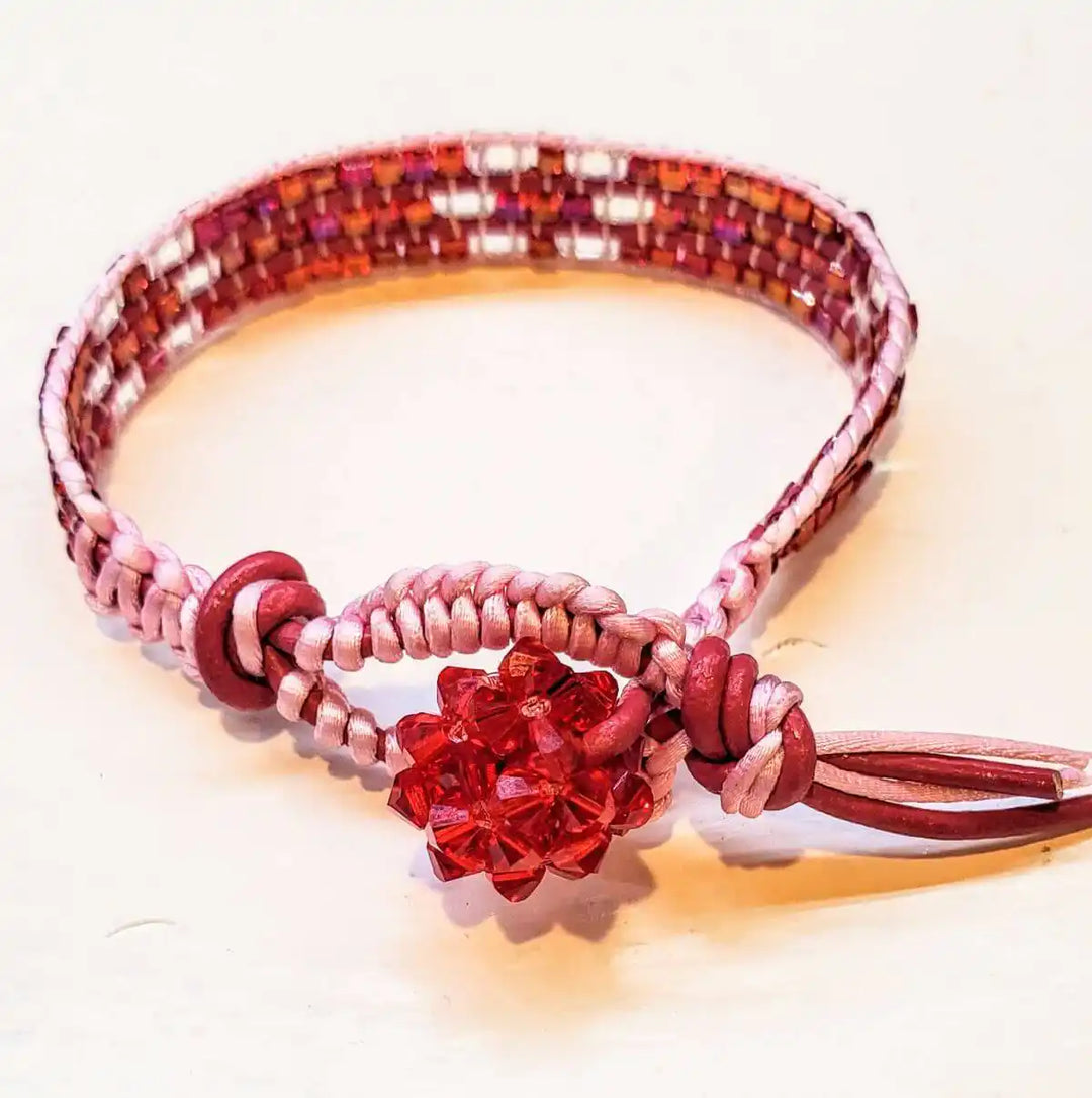 Leather Silk Bead Woven Crystal Button Bracelet with red crystal and pink silk details.