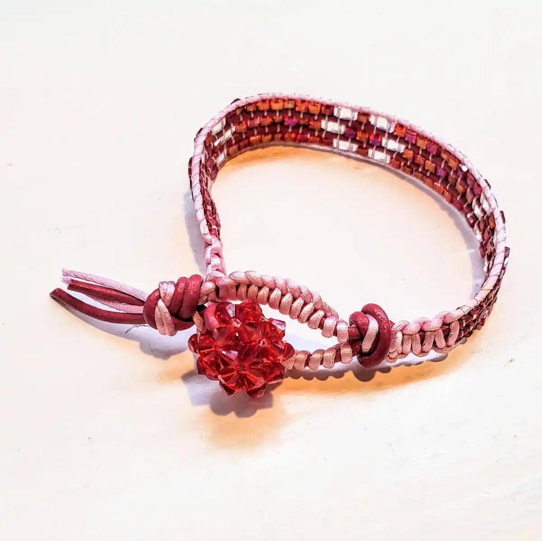 Leather Silk Bead Woven Crystal Button Bracelet featuring red leather and sparkling pink Swarovski crystals.