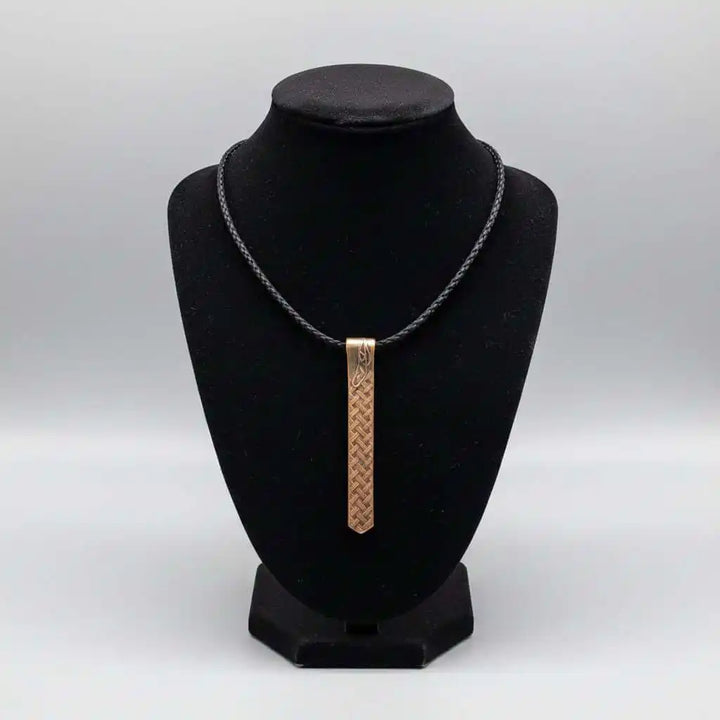 Copper Weave Embossed Necktie Necklace displayed on a black bust showcasing its unique design.