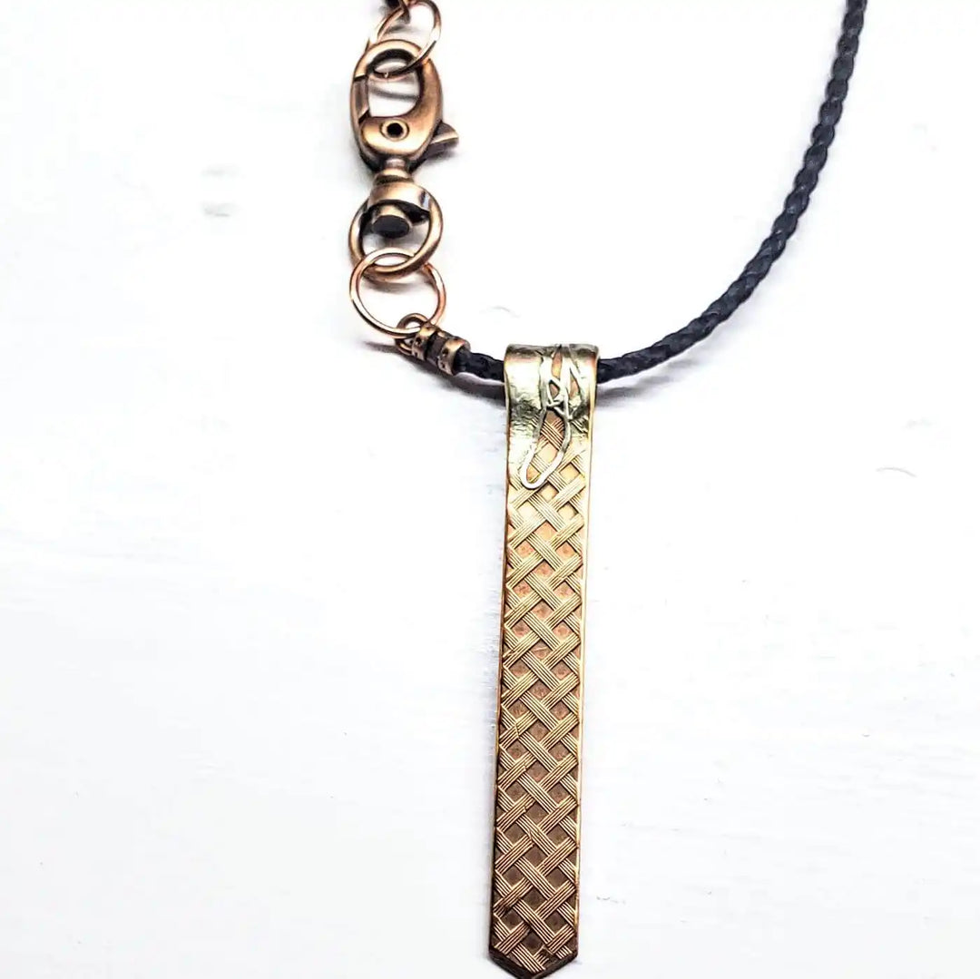 Copper Weave Embossed Necktie Necklace featuring a bold copper pendant and braided strap.