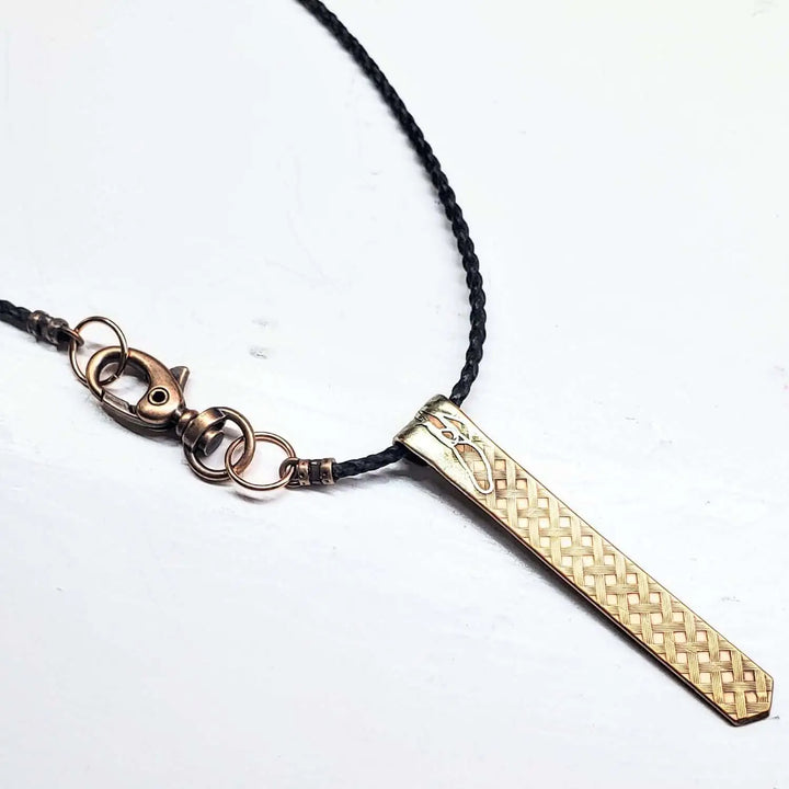 Copper Weave Embossed Necktie Necklace featuring a bold copper pendant and braided leather cord.