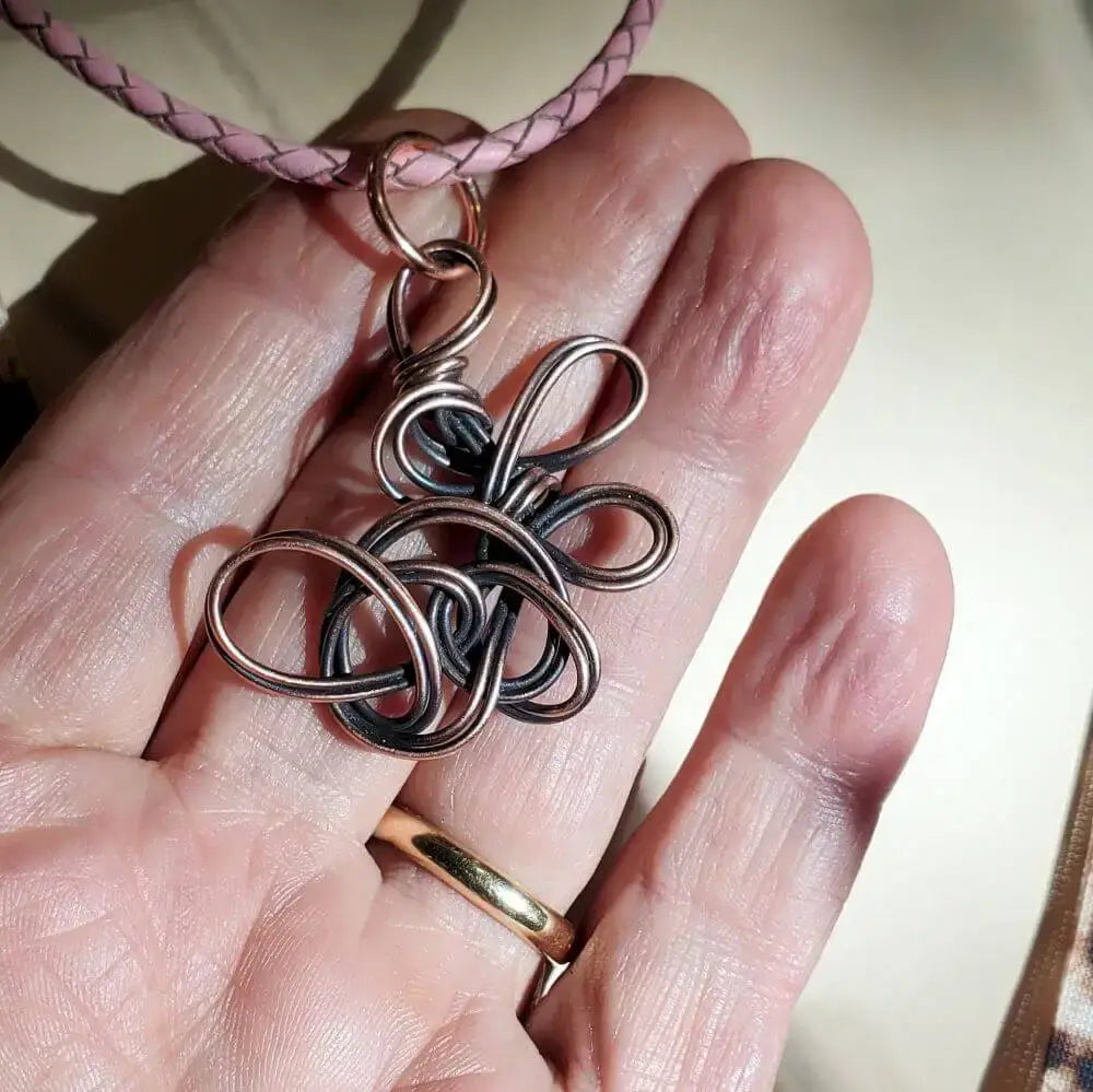 Reversible Interchangeable Copper Wire Sculpted Necklaces showcased in a hand, highlighting unique handmade design.