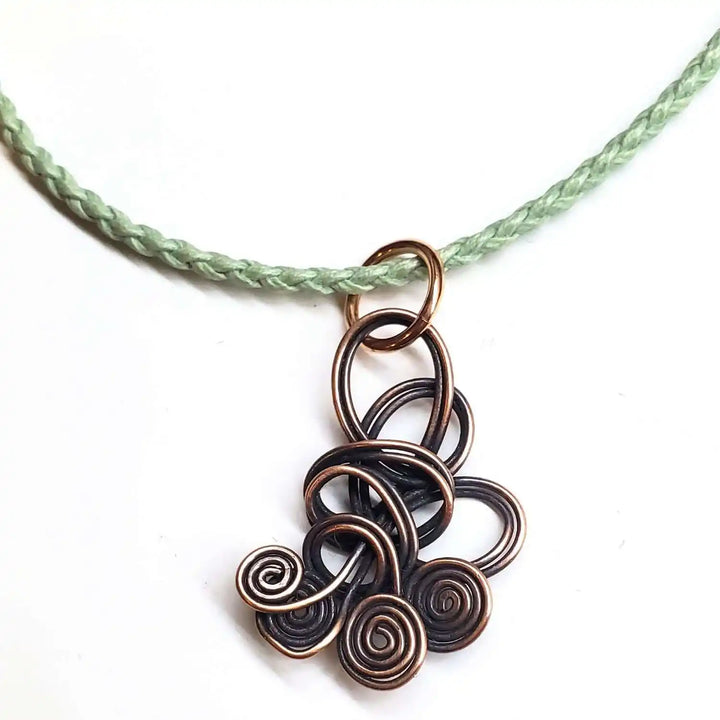 Reversible Interchangeable Copper Wire Sculpted Necklaces featuring intricate swirls and a braided cord.