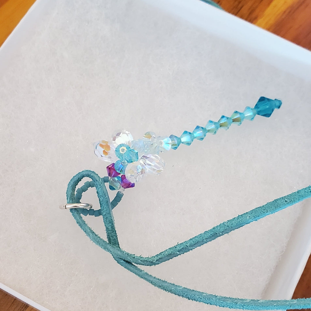 Beaded 3-D Rearview Mirror Colored Crystal Dragonfly Charm with teal and aquamarine crystals on a suede cord.