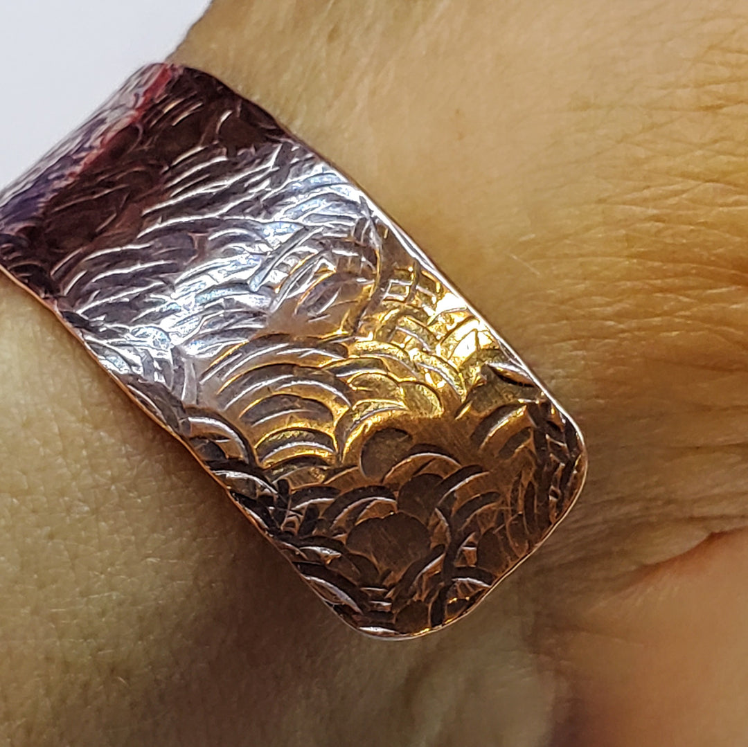 copper bar with embossed design on a wooden surface