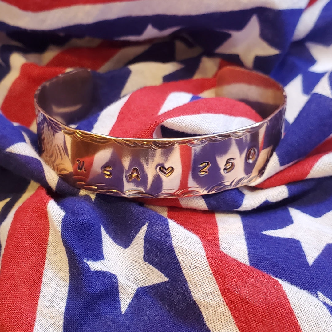 Copper bracelet with engraved text on an American flag background