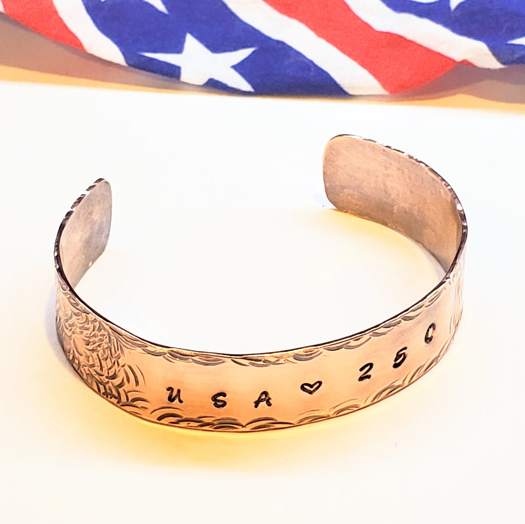 Copper bracelet with engraved text USA 250 on a white background