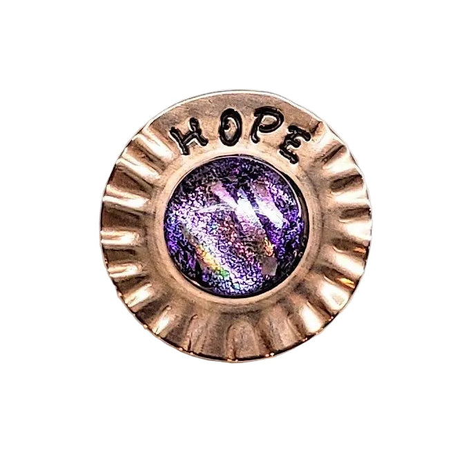 A round, scalloped copper-toned metal brooch featuring the word &