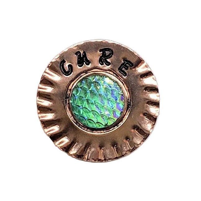A round copper-toned button  magnet with a scalloped edge, featuring the word &