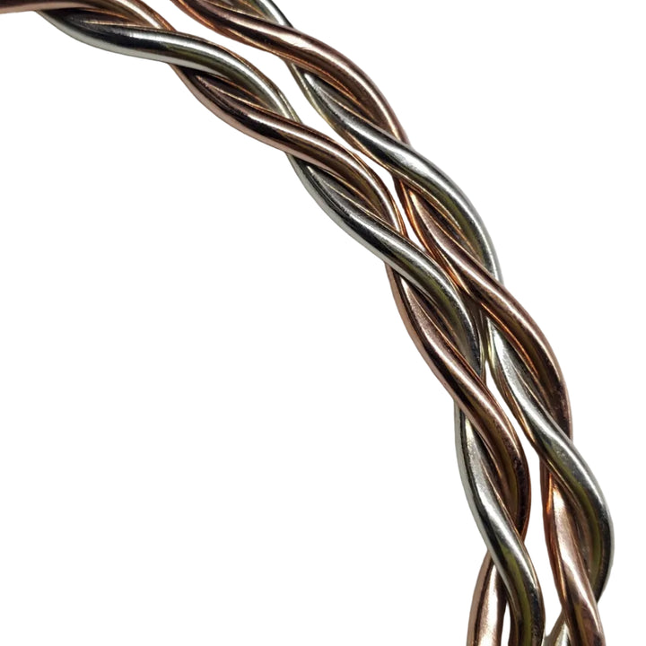Close-up of intertwined 12-gauge copper and sterling silver wire on a handmade twisted cuff bracelet