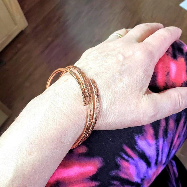 Unisex 8 Gauge Adjustable Hammered Copper Overlap Bangle worn on wrist, showcasing its bold design and unique artistry.
