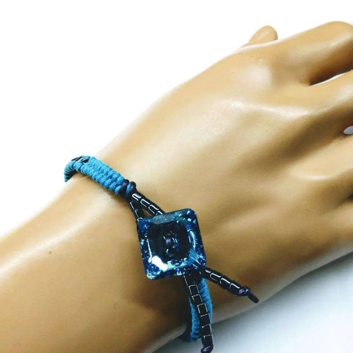 Aqua Hematite Bead Braided Swarovski Crystal Button Bracelet worn on a hand, featuring aqua beads and sparkling crystals.