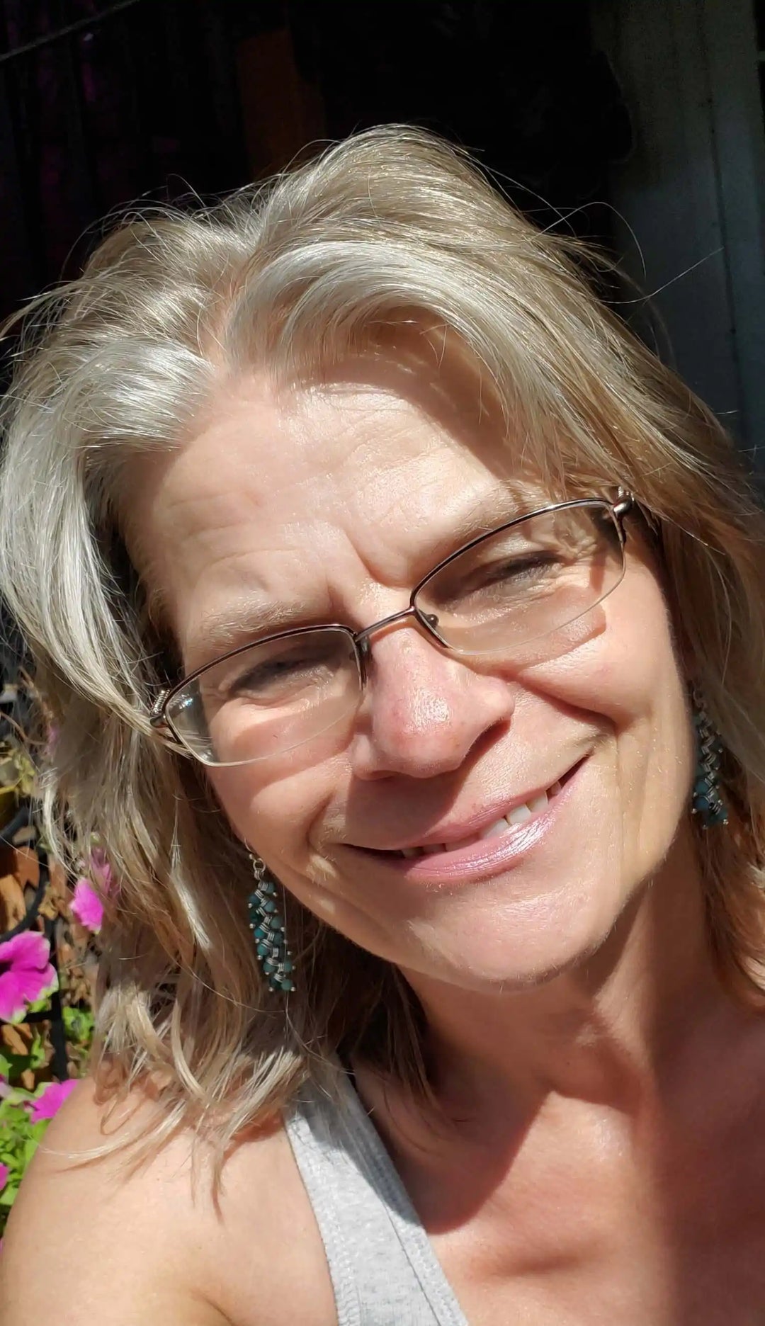 Seen On Jane The Virgin Silver Turquoise Wire Coil Earrings worn by a smiling woman with glasses outdoors.