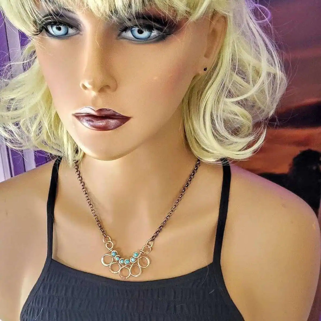 Seen on Ashley Liao Copper Turquoise Wire Wrapped Necklace worn by a mannequin with a stylish look.