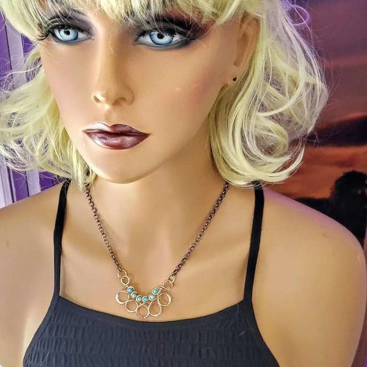 Seen on Ashley Liao Copper Turquoise Wire Wrapped Necklace worn by a mannequin with a stylish look.