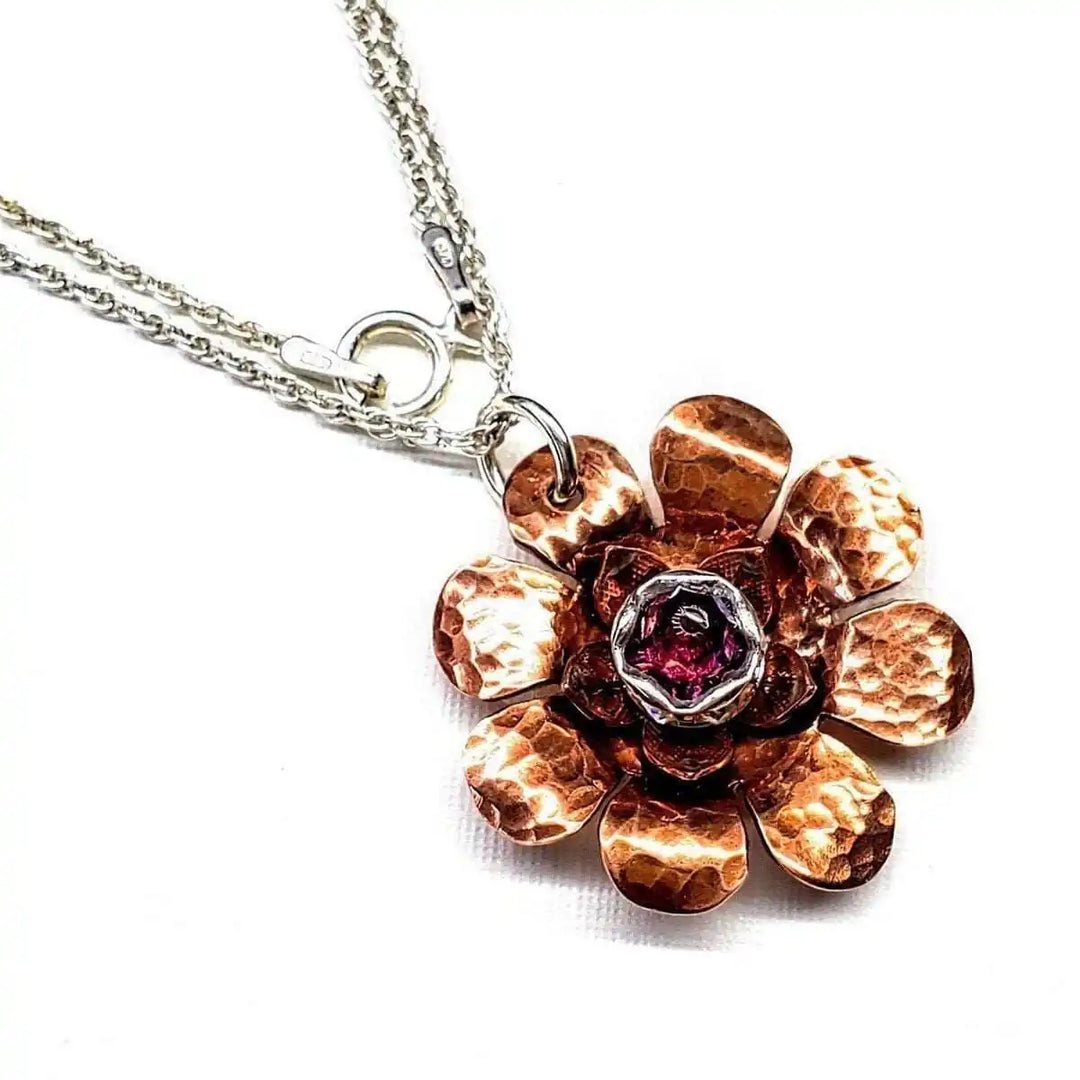 Copper Crystal Flower Blossom Fidget Spinner Necklace with a hammered metal flower design and a pink crystal centerpiece