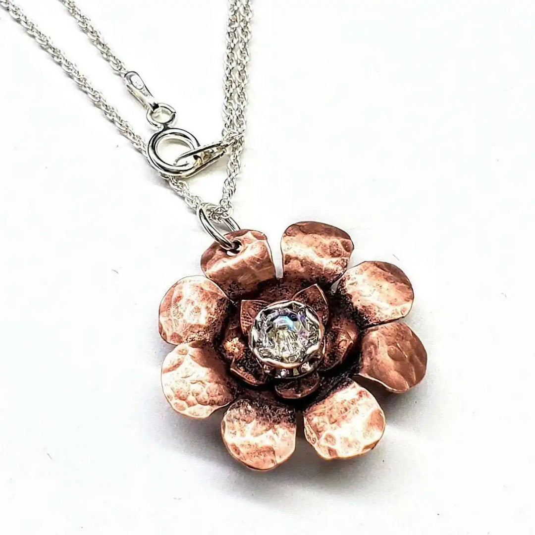 Copper Crystal Flower Blossom Fidget Spinner Necklace with a hammered copper flower pendant and crystal centerpiece.