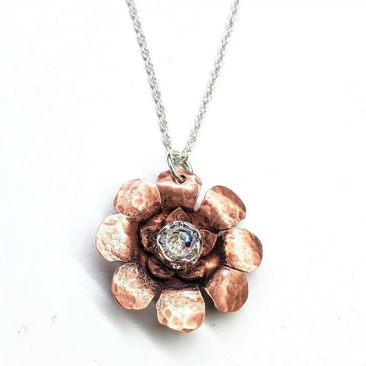 Copper Crystal Flower Blossom Fidget Spinner Necklace featuring a hammered copper flower design with a crystal center.