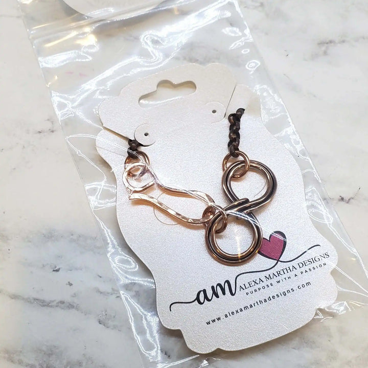 Wire Sculpted Copper Double Infinity Chain Bracelet displayed on a packaging by Alexa Martha Designs.