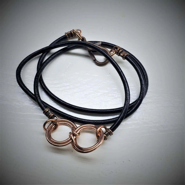 Copper Double Infinity Gender Neutral Leather Wrap Bracelet featuring intertwined copper infinity symbols on black leather.