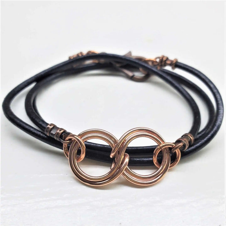Copper Double Infinity Gender Neutral Leather Wrap Bracelet featuring intertwined copper infinity symbols on black leather.