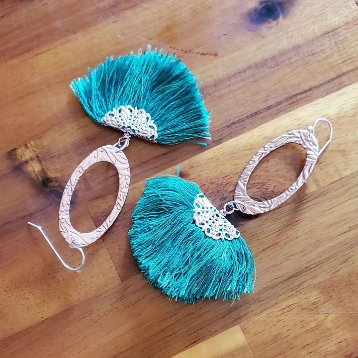Rose Gold Filigree Silk Tassel Earrings Copper Embossed with vibrant teal silk tassels and ornate copper ovals.
