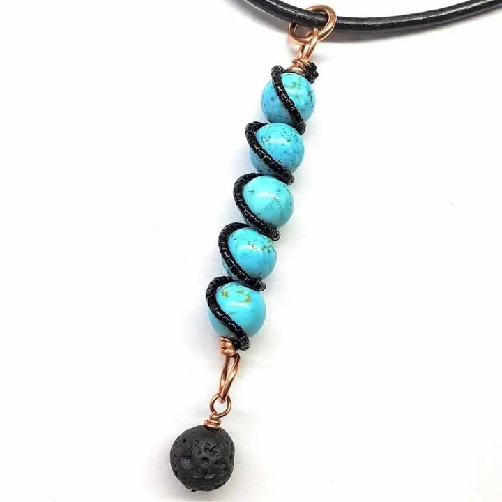 Handmade copper turquoise pendant with lava rock charm, showcasing vibrant turquoise beads and a black lava rock.