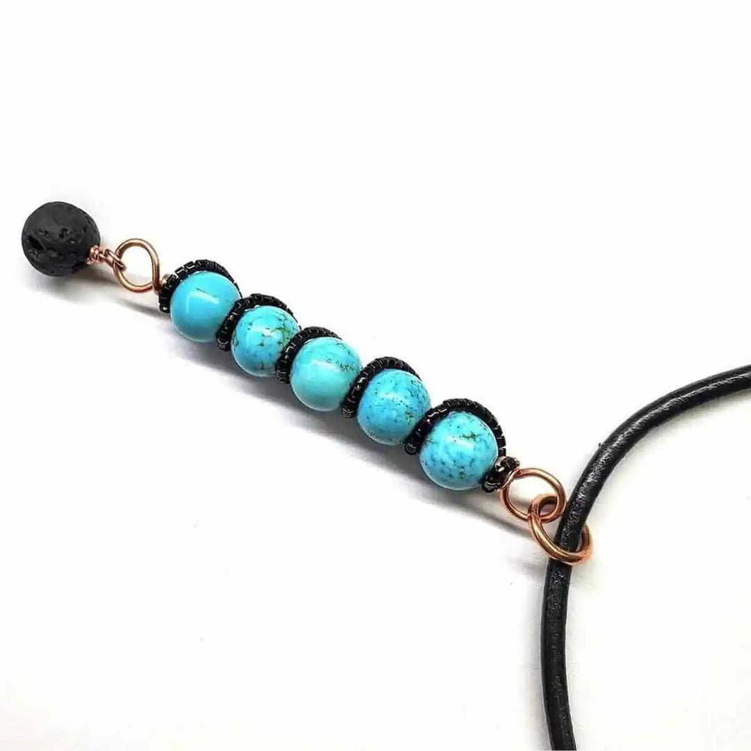 Copper turquoise pendant with lava rock charm featuring turquoise beads and a lava rock charm.