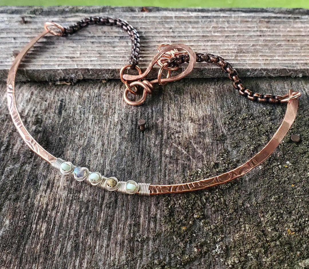 Ergonomic Copper Sculpted Embossed Wire Gemstone Choker featuring Peruvian opal gemstones on wood background.