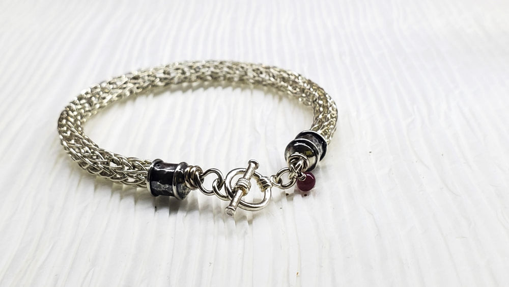 AMD1266Handmade 10mm Silver Viking Knit Bracelet with Ruby CharmJewelryBracelet$ 190.00Alexa Martha Designs